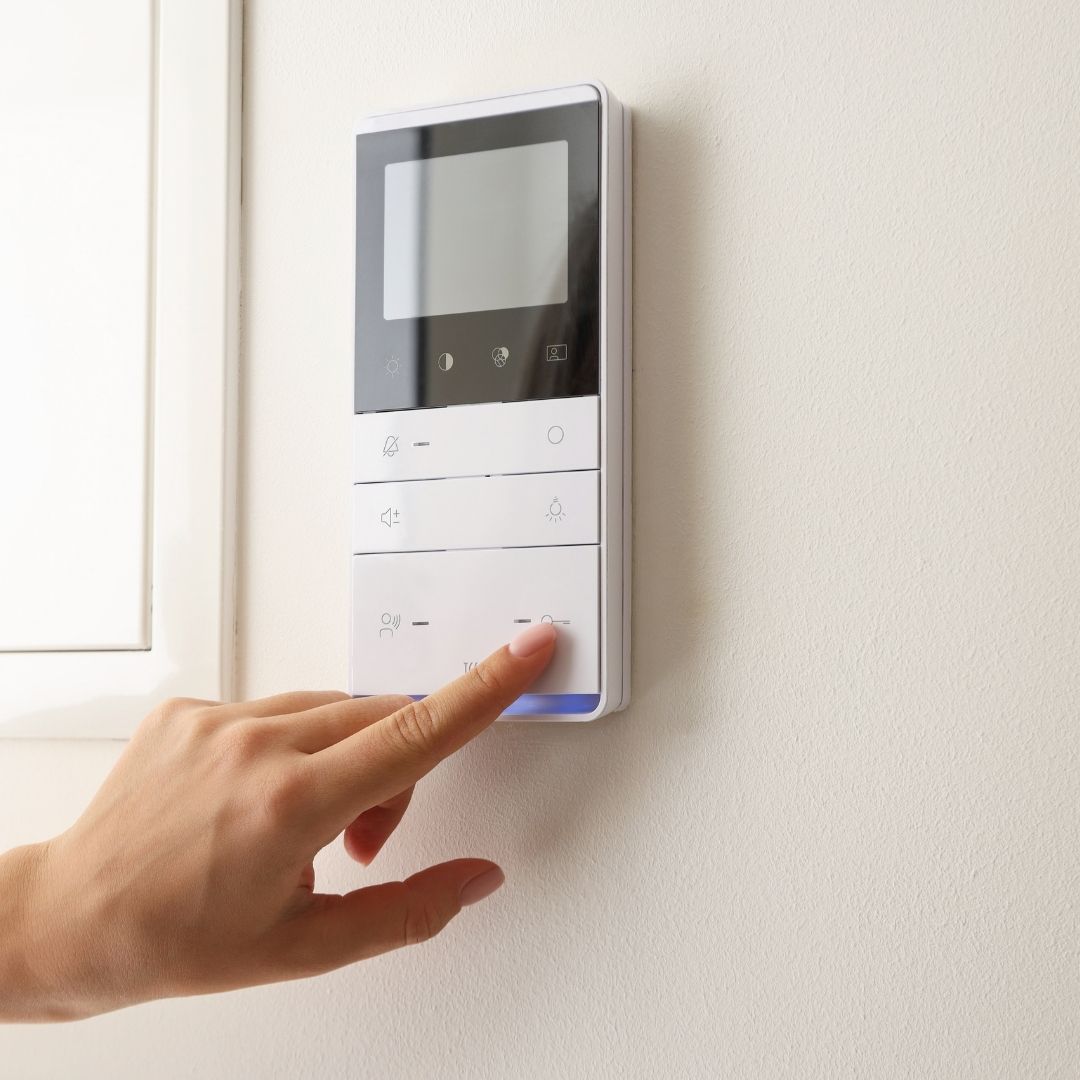 person adjusting thermostat