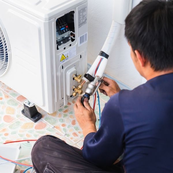 HVAC tech repairing AC