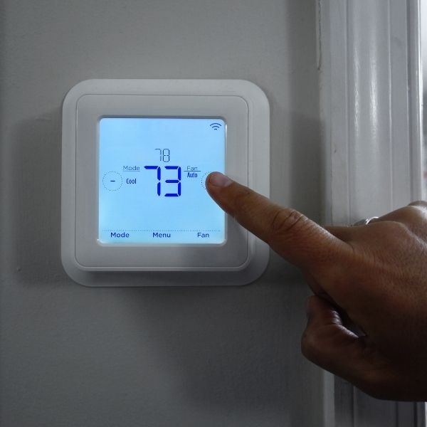 person adjusting thermostat