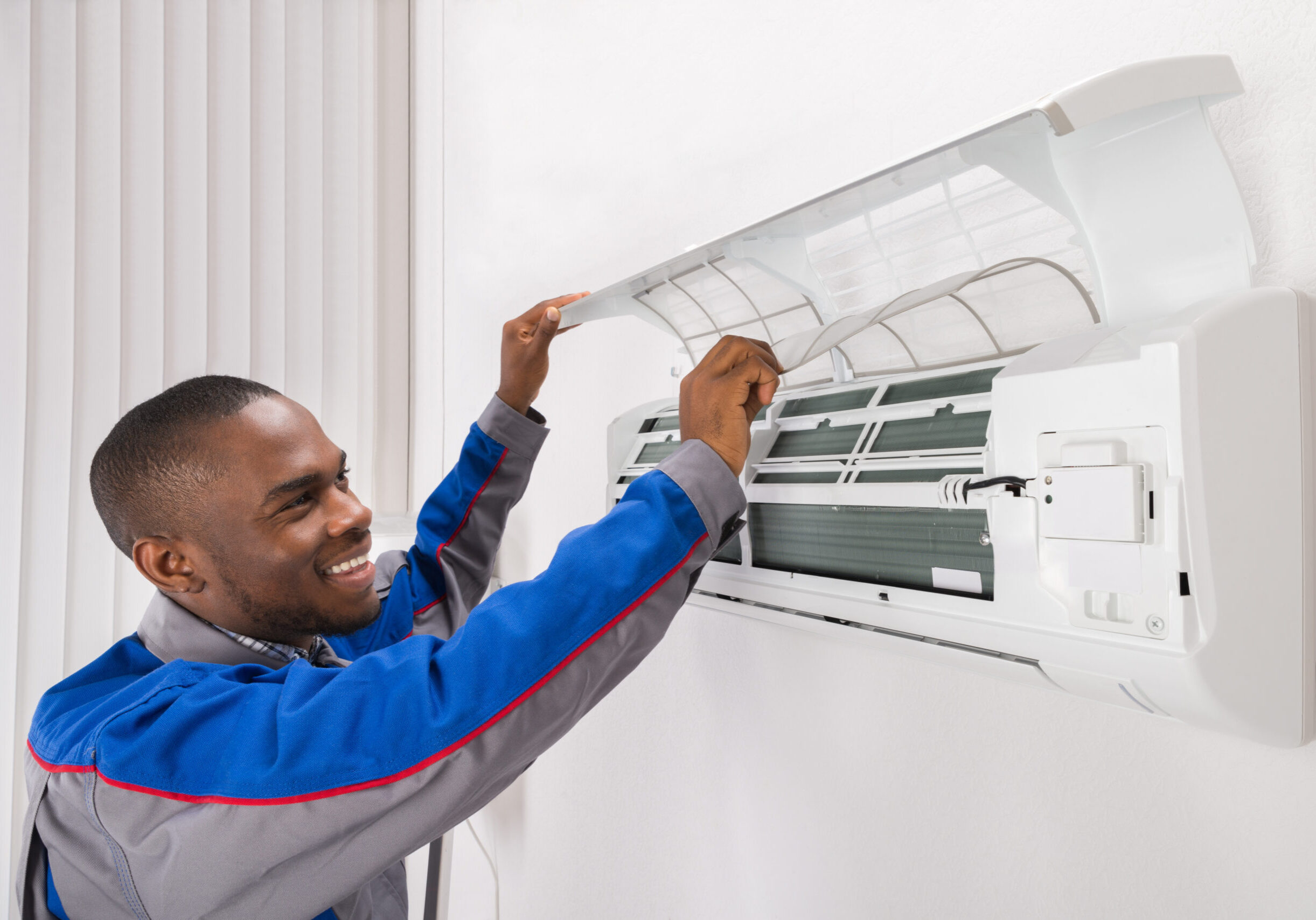 Happy Male Technician Checking Air Conditioner At Home
