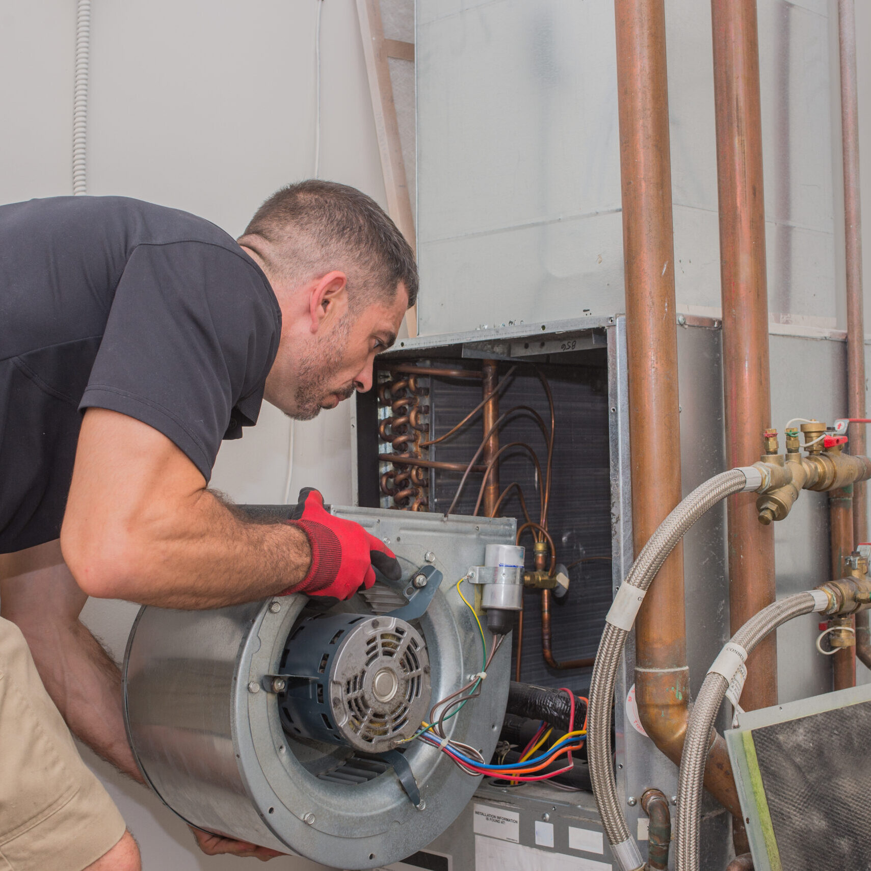 Hvac repair technician removing a blower motor from air handler